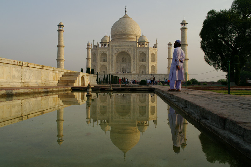 Man reflecting on the Taj Mahal's reflection