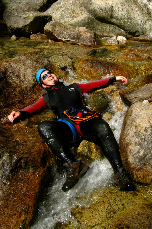 Justin laying in a stream before canyoning (aqua rando) in Corsica