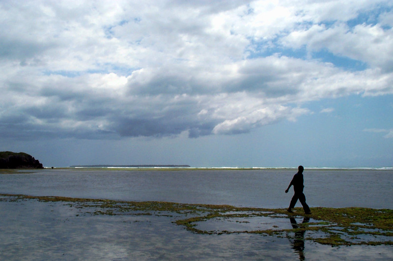 man walking in the indian ocean at low tide