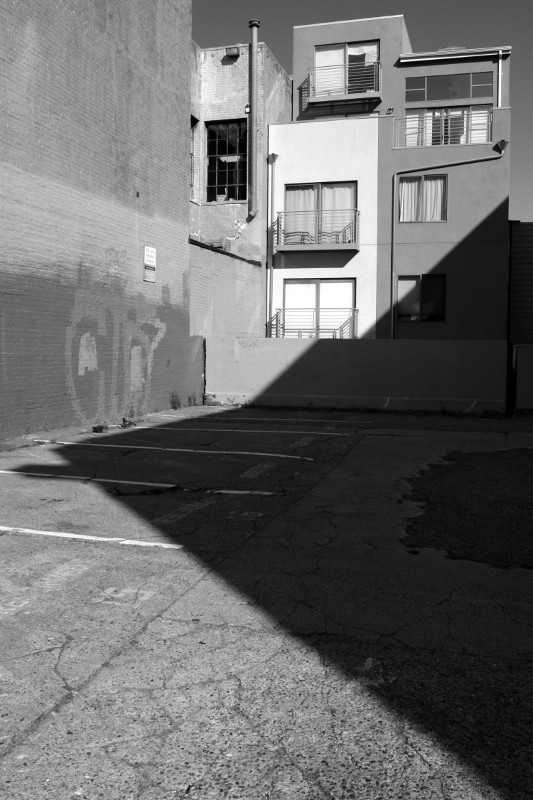 A shadow cuts across an empty lot
