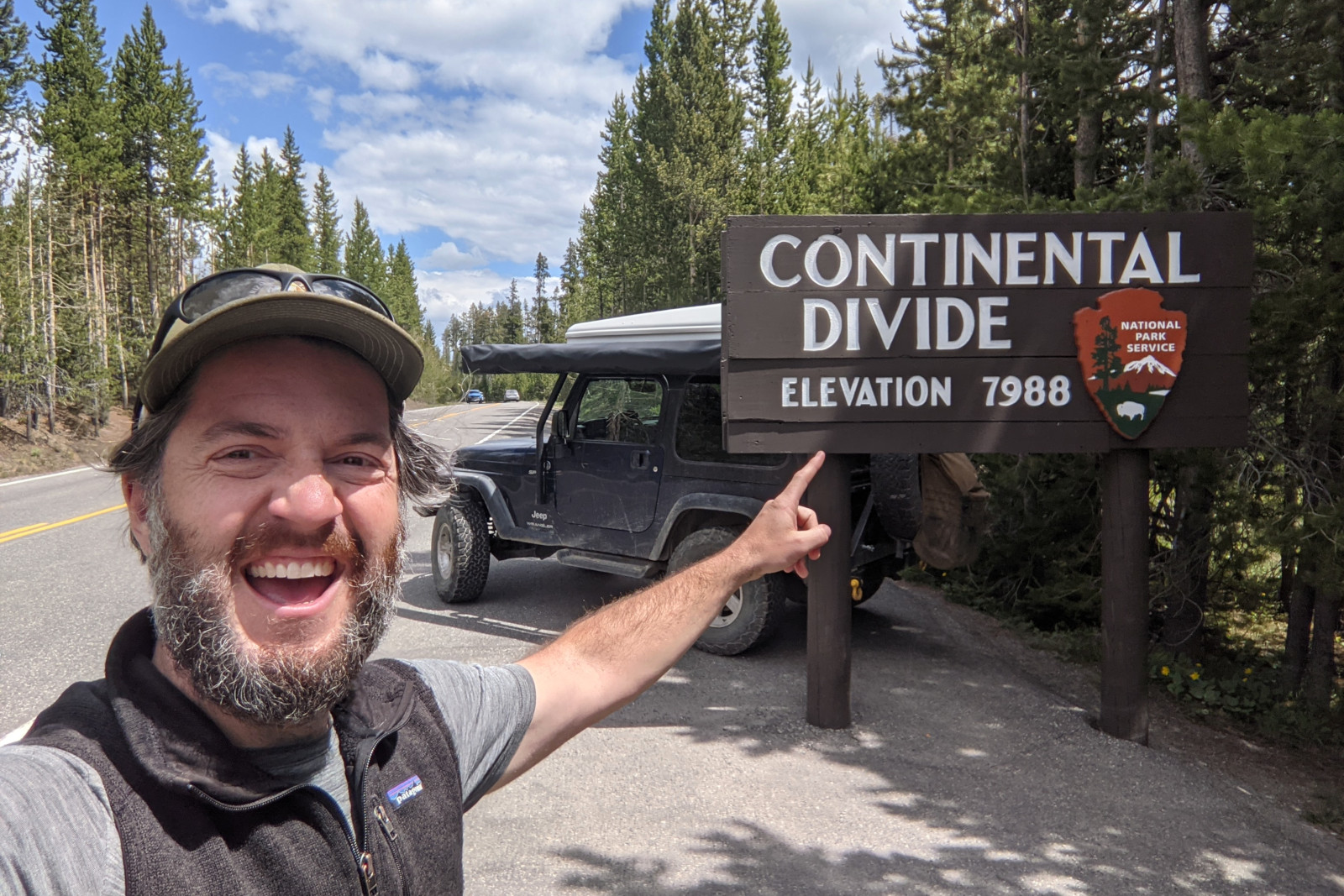 Justin pointing at a Continental Divide sign in Yellowstone National Park