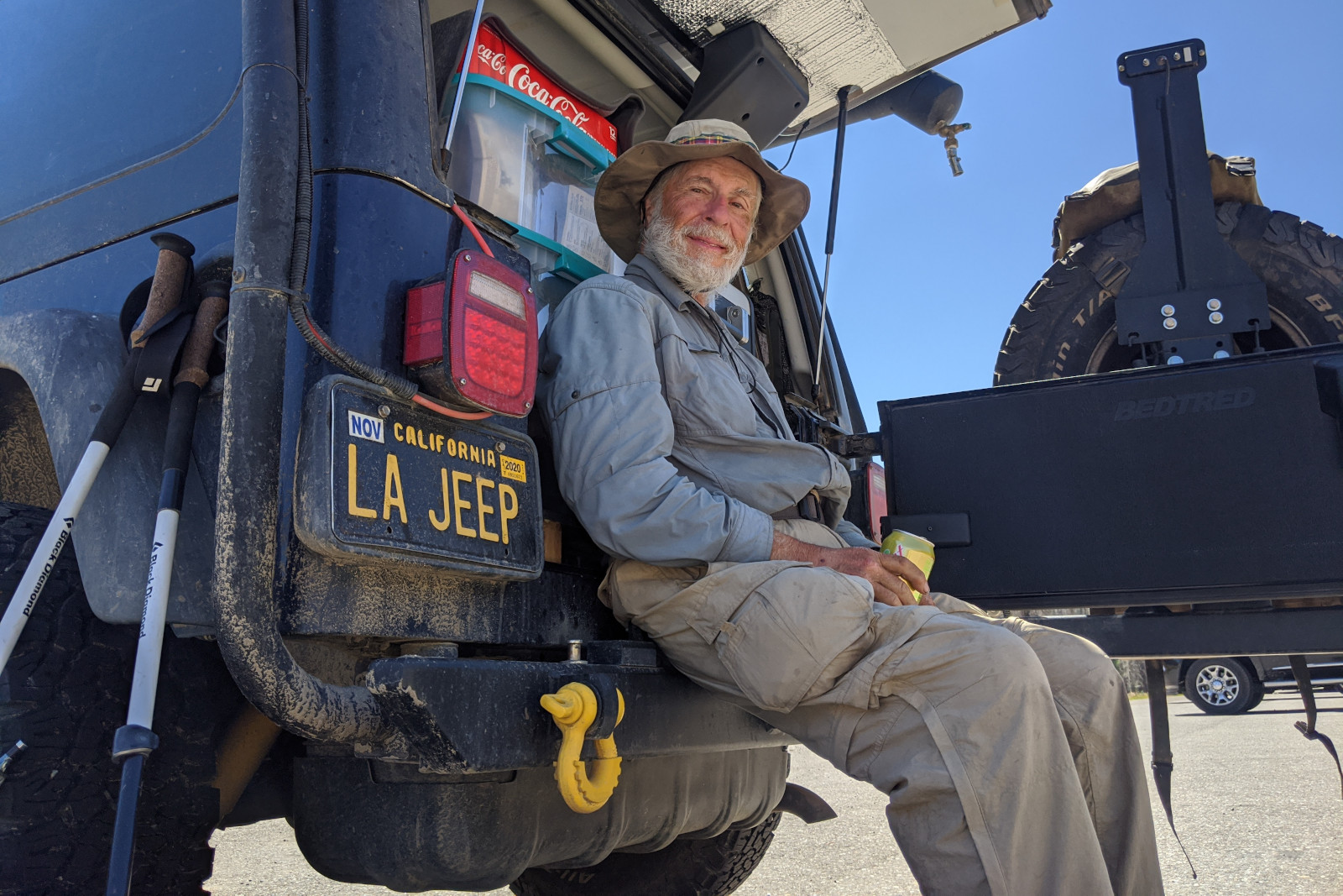 Dad (aka Tartan) sitting on the back bumper of La Jeep with a can of squirt