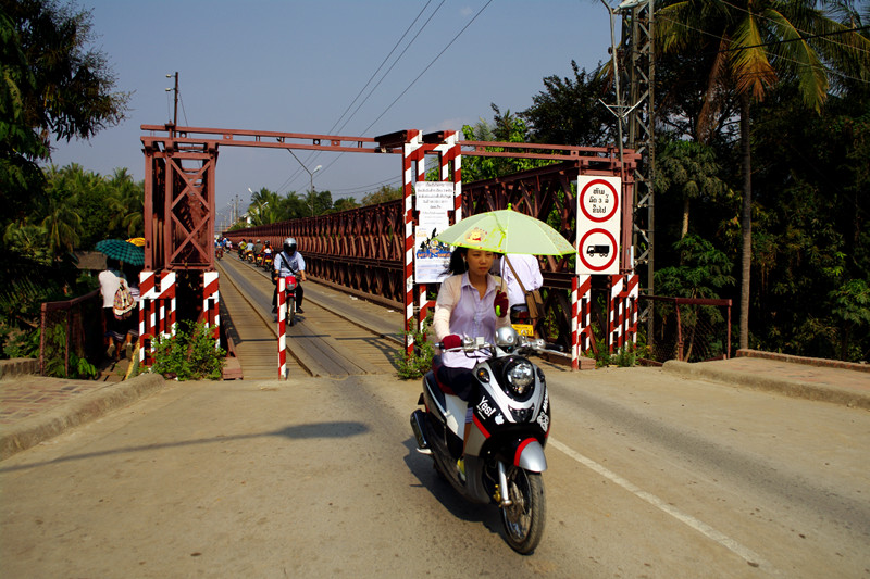 Riding a scooter with an umbrella in Luang Prabang, Laos