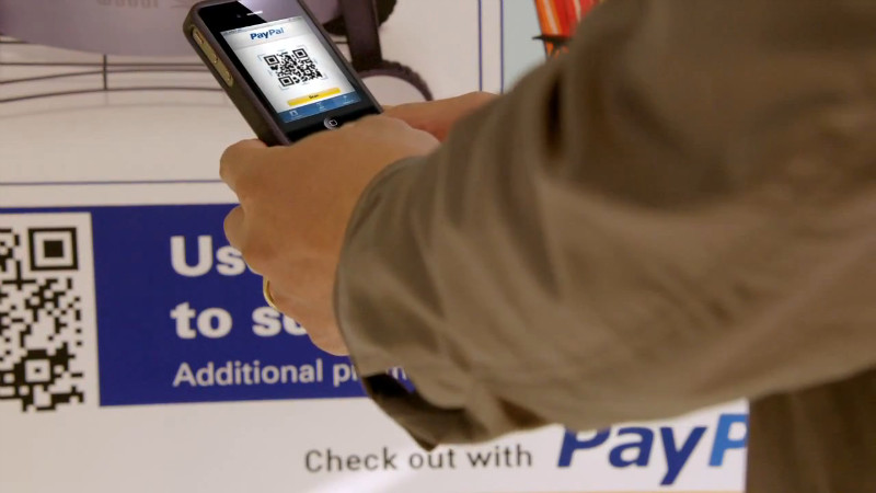 Screenshot from PayPal's Future of Shopping video using a QR Code that points to justinsomnia.org