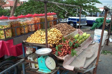 outdoor fruit vendor. the lychee fruit is very popular here (see it in the lower-right)