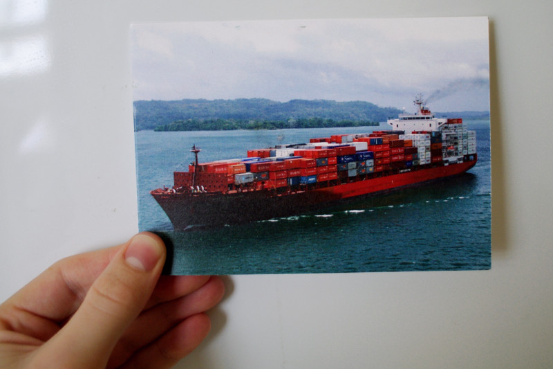 Postful container ship postcard in hand