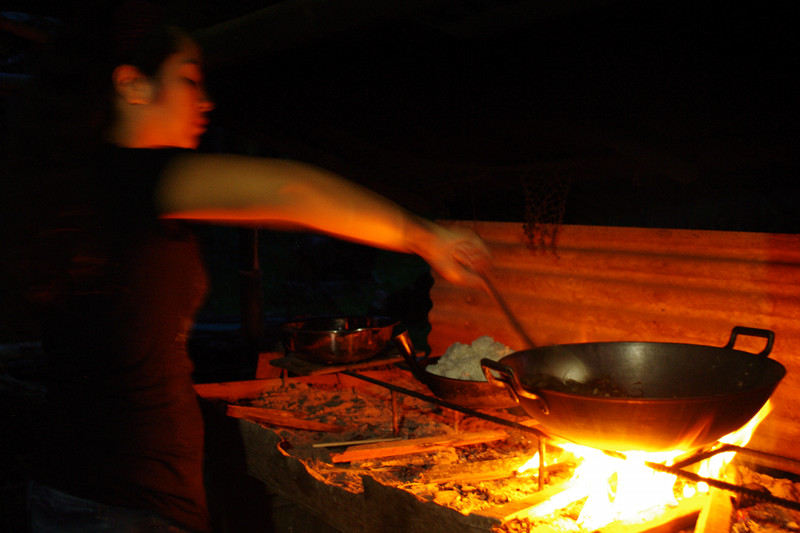 Fatima stirs the rambit adobo over an open fire